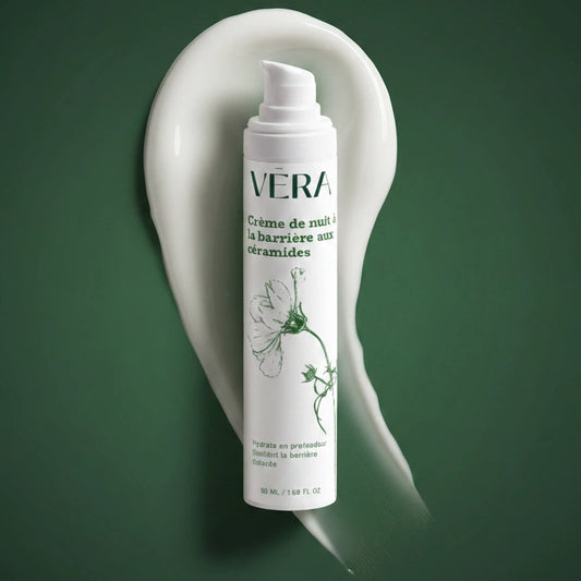Flacon pompe de la crème de nuit barrière aux céramides VERA devant une trace de crème blanche sur fond vert.