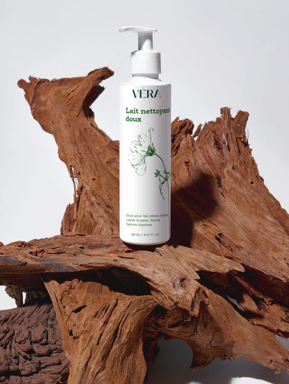 Lait nettoyant doux VERA pour le visage, flacon pompe posé sur bois naturel.