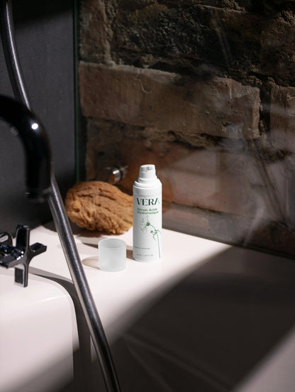Flacon sérum acide hyaluronique VERA posé dans une salle de bain, routine soin visage hydratant