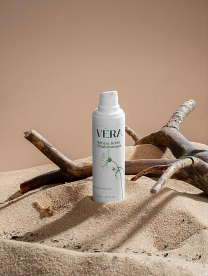 Sérum acide hyaluronique VERA sur sable et bois, soin naturel hydratation intense peau