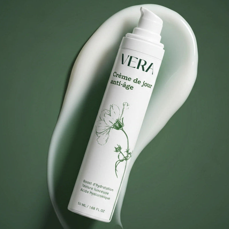Crème de jour anti-âge VERA en flacon pompe, posée en diagonale sur une trace de crème.