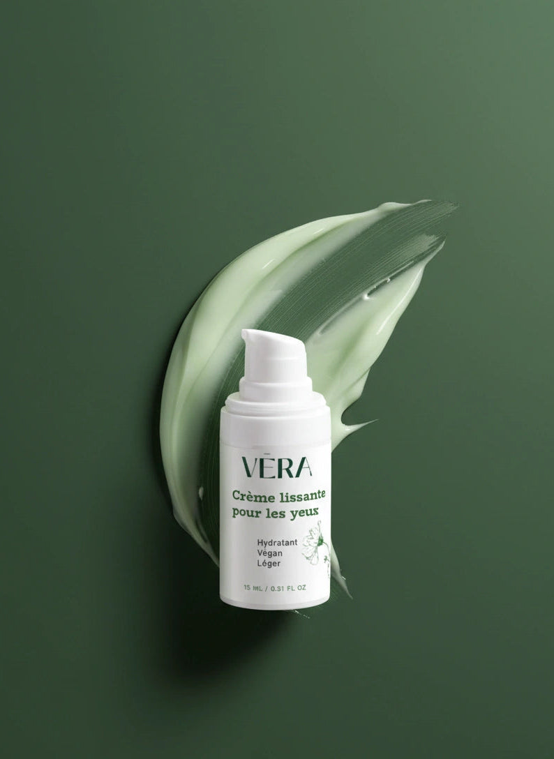 Flacon de crème lissante pour les yeux VERA sur fond vert, devant une trace de texture de crème verte.