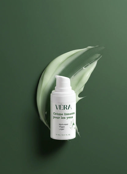 Flacon de crème lissante pour les yeux VERA sur fond vert, devant une trace de texture de crème verte.